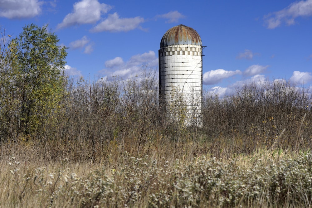 Edificio in cemento marrone e bianco sul campo di erba marrone sotto il cielo blu durante il giorno