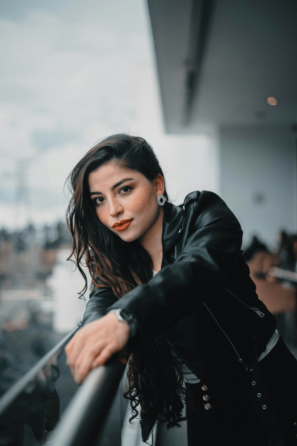 woman in black coat holding her hair