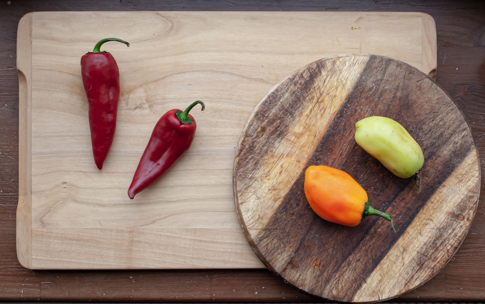 red and yellow chili pepper on brown wooden chopping board