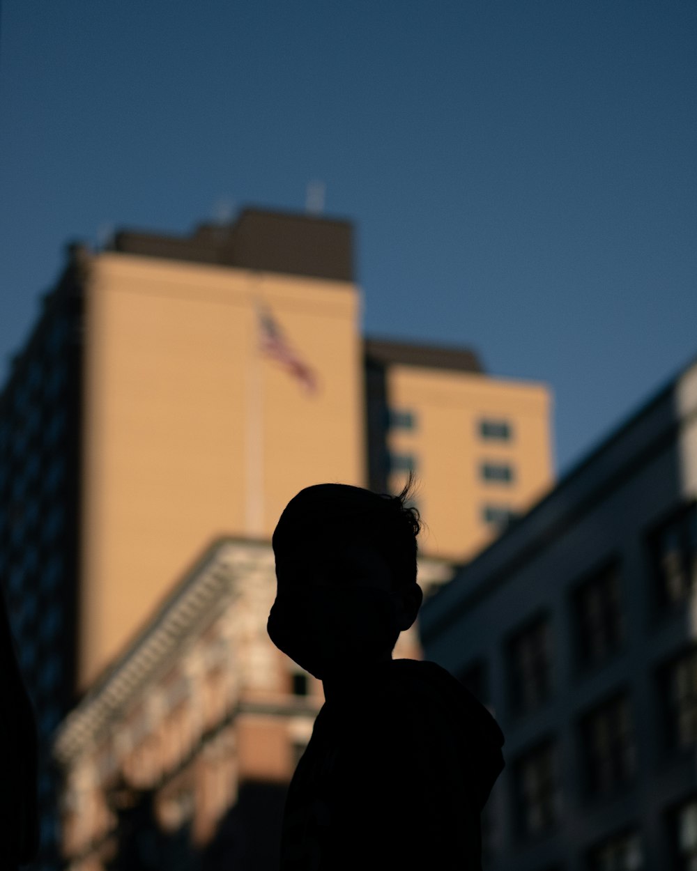 man in black shirt standing near brown concrete building during daytime