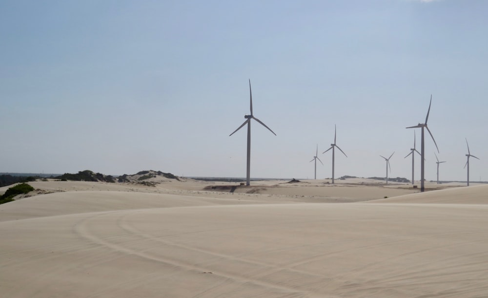 turbinas eólicas en arena marrón bajo cielo gris