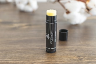 black and yellow plastic bottle on brown wooden table