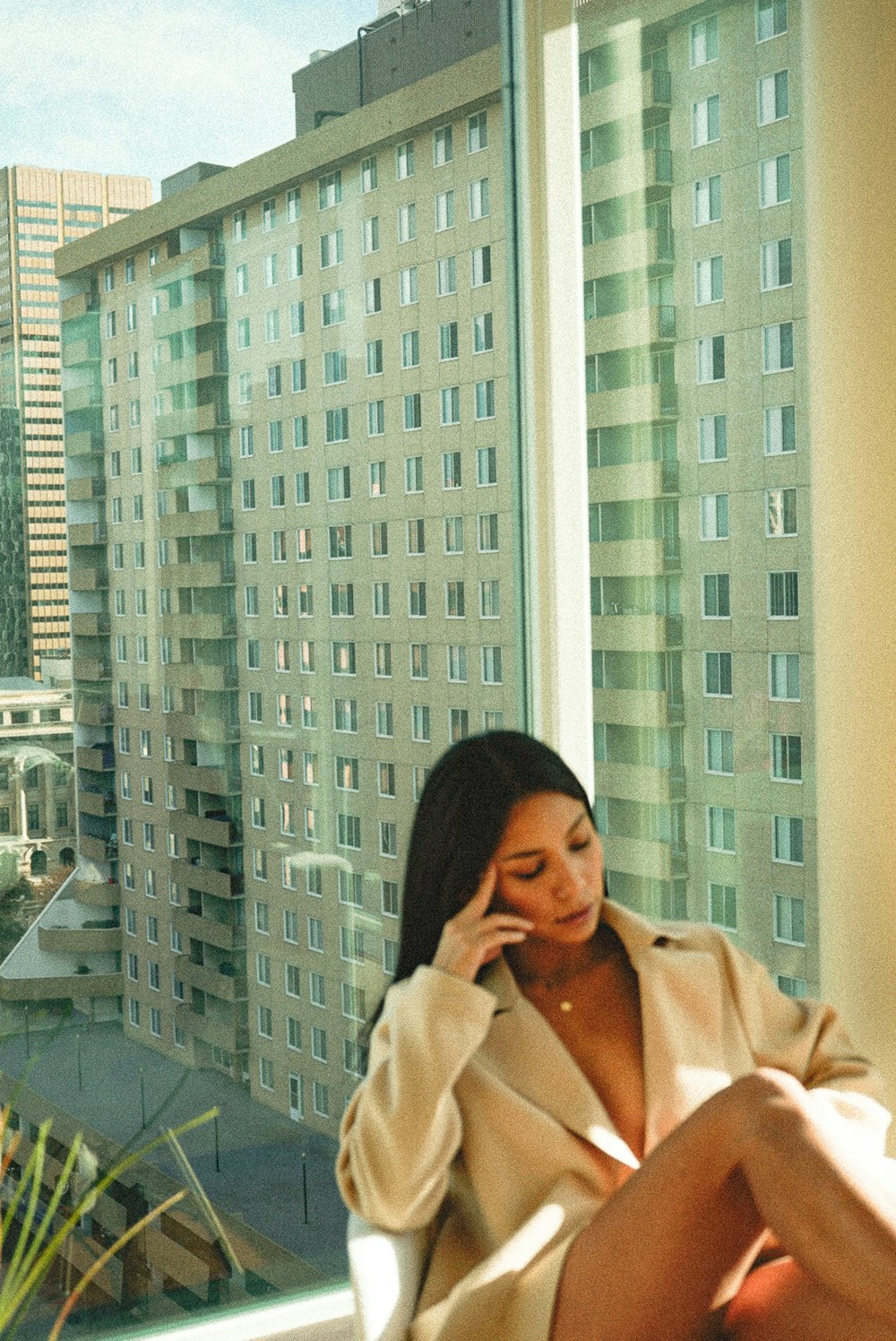 woman in beige coat standing near glass wall