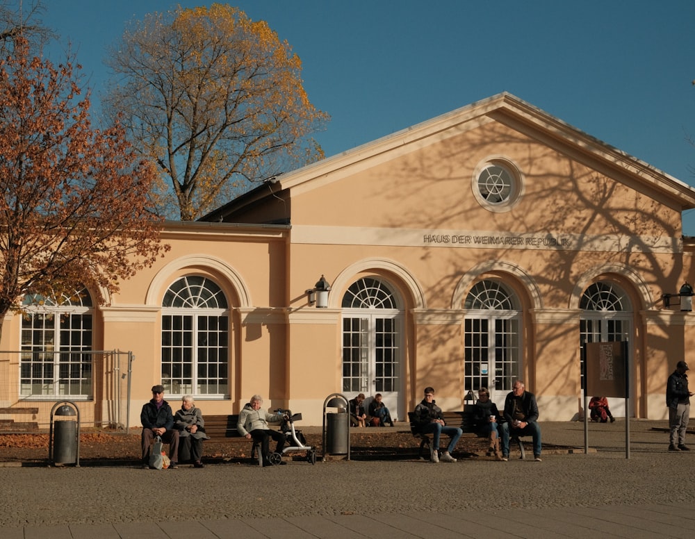 people standing in front of white concrete building during daytime