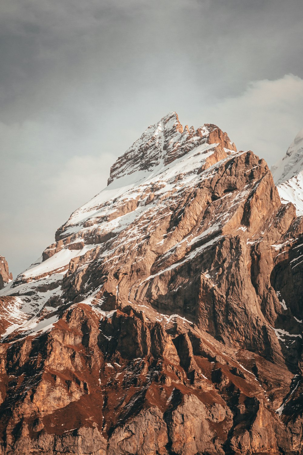 brown and white mountain under white clouds during daytime