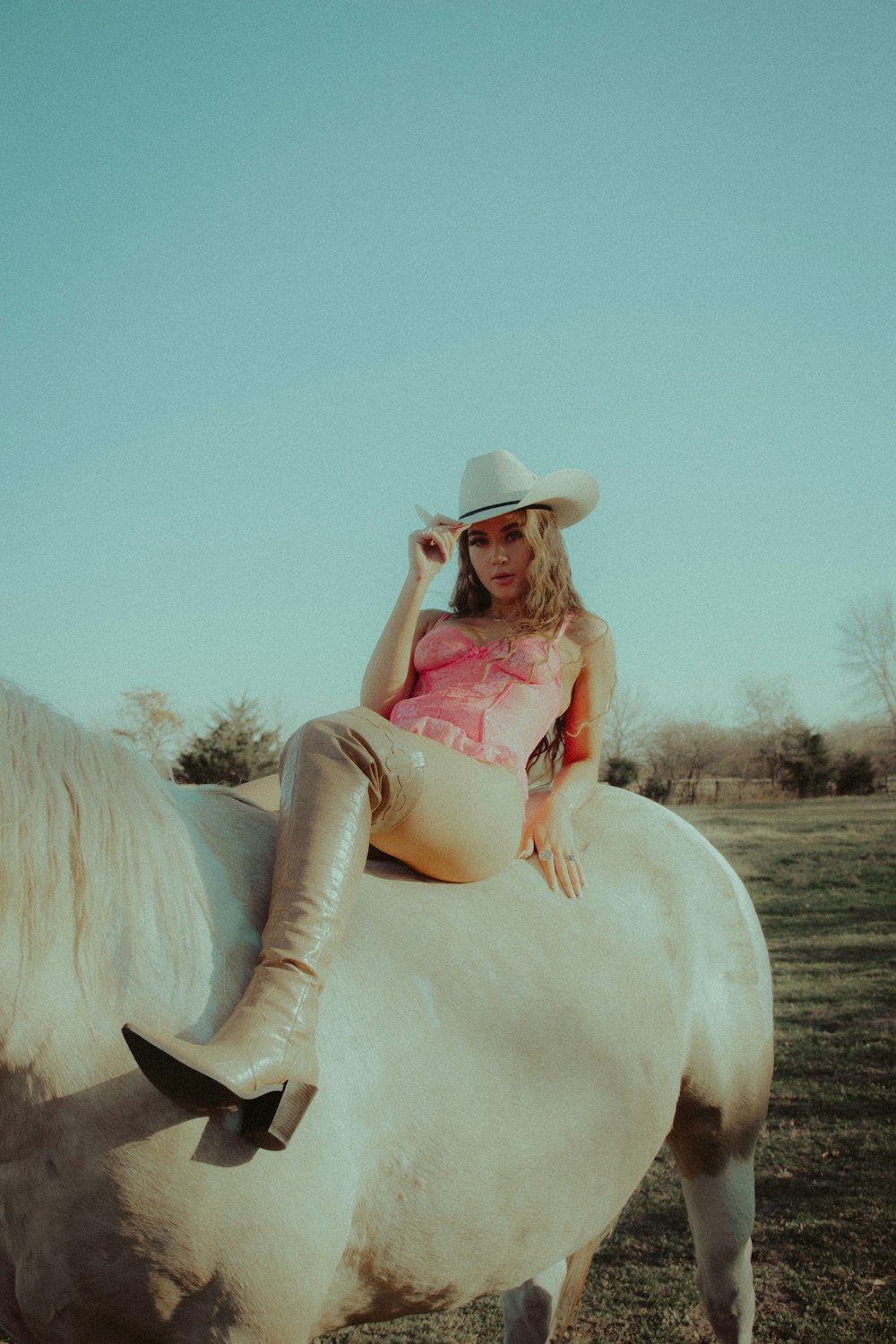 woman in red dress sitting on white horse