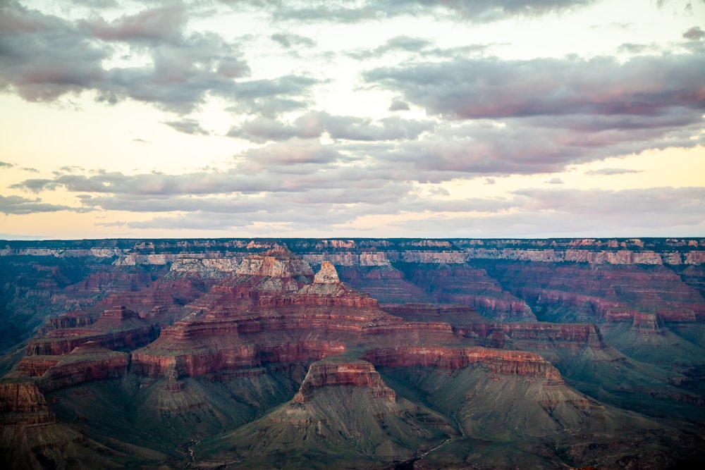 brown rock formation under white clouds during daytime