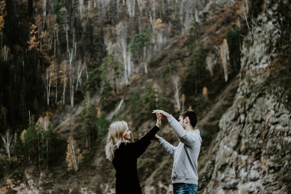 woman in black jacket and gray pants raising her right hand