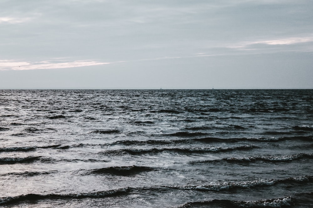 ocean waves under white sky during daytime