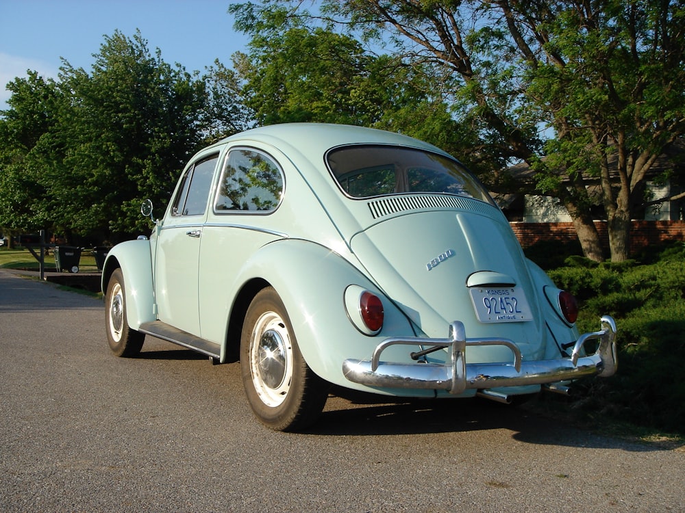 white volkswagen beetle parked on gray concrete road during daytime