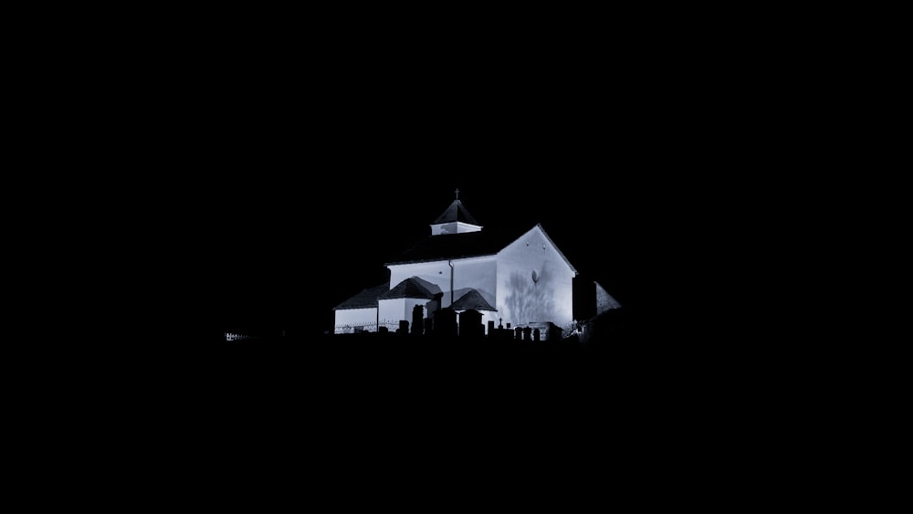 white and black house with lights turned on during night time