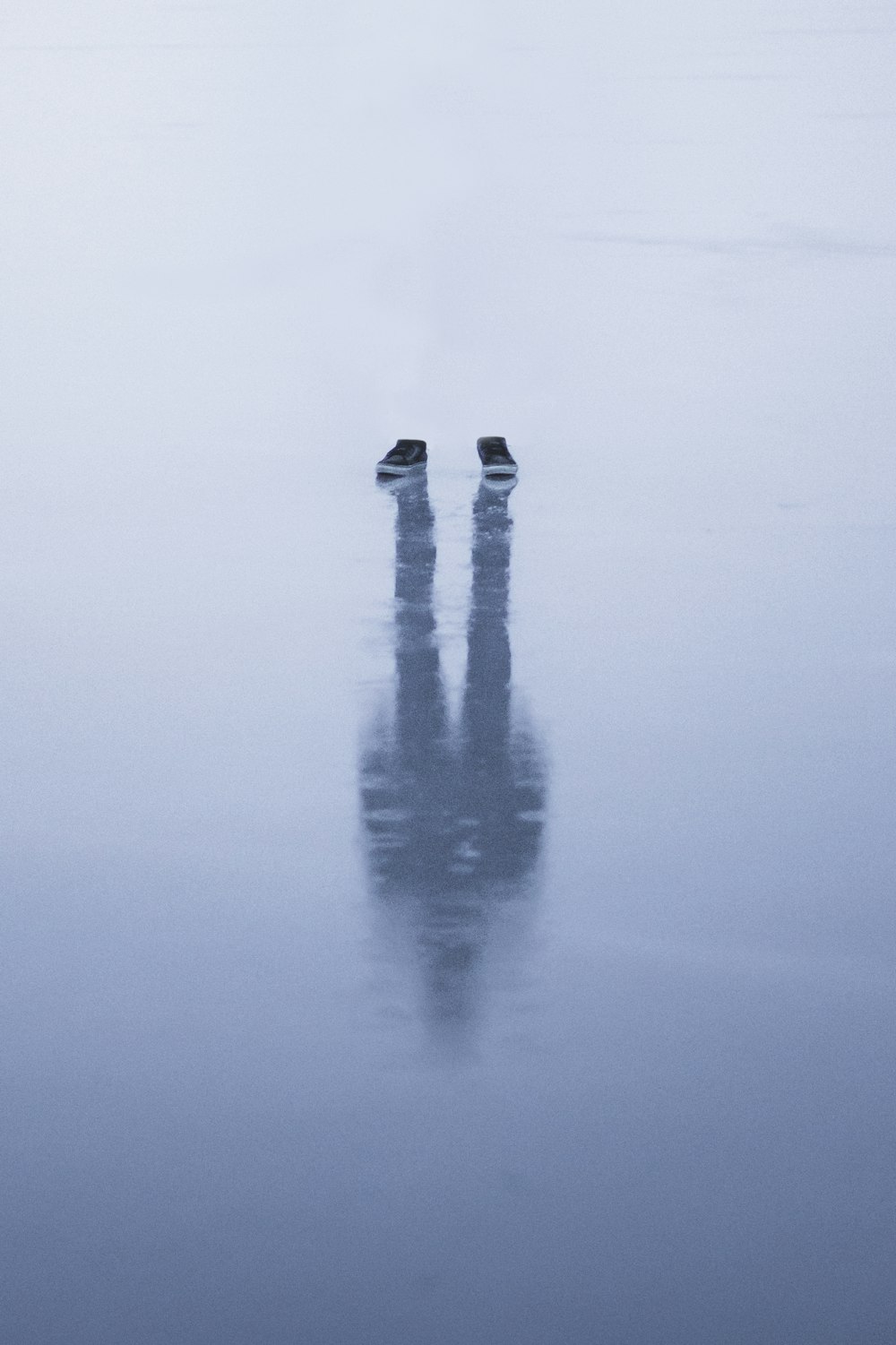 person in black pants standing on water