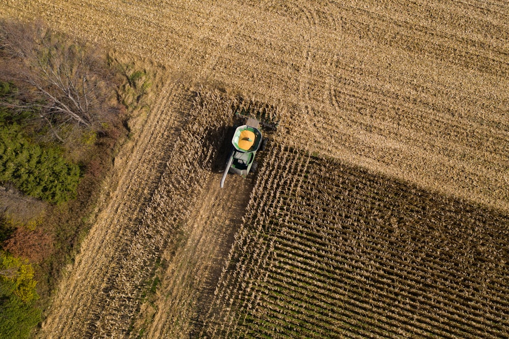 green and black tractor on brown field during daytime