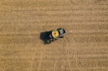 Wide shot of a tractor equipped with Agricore sensors moving through a green crop field.