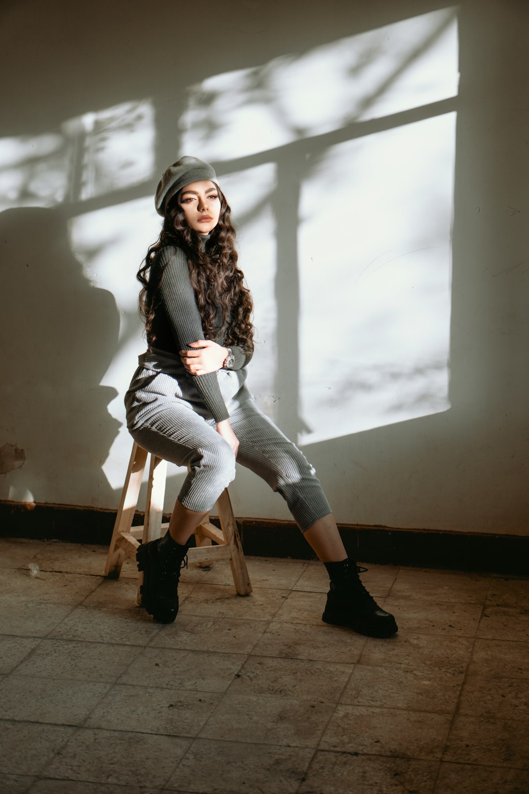 woman in black jacket and gray pants sitting on brown wooden seat