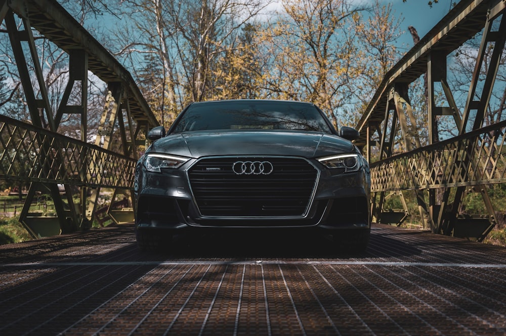 a black car is parked on a bridge