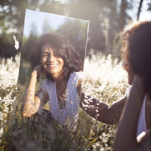 woman in blue and white floral shirt holding her face