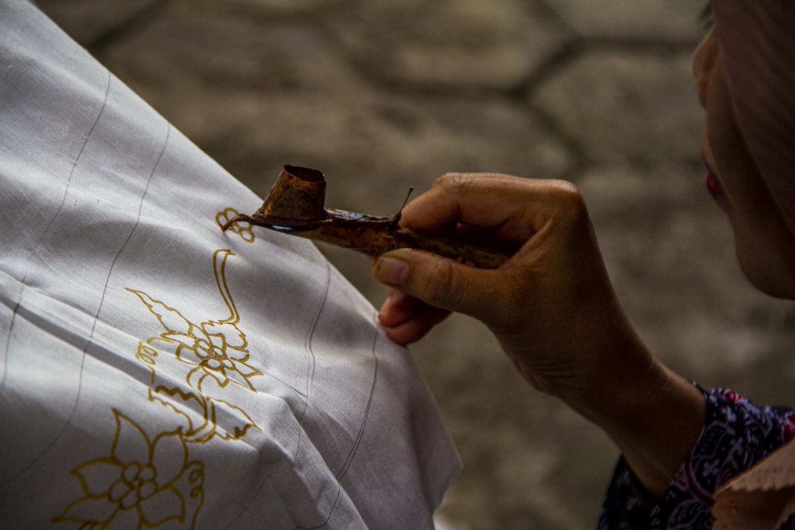 Batik artisan at work with traditional canting tool in Yogyakarta
