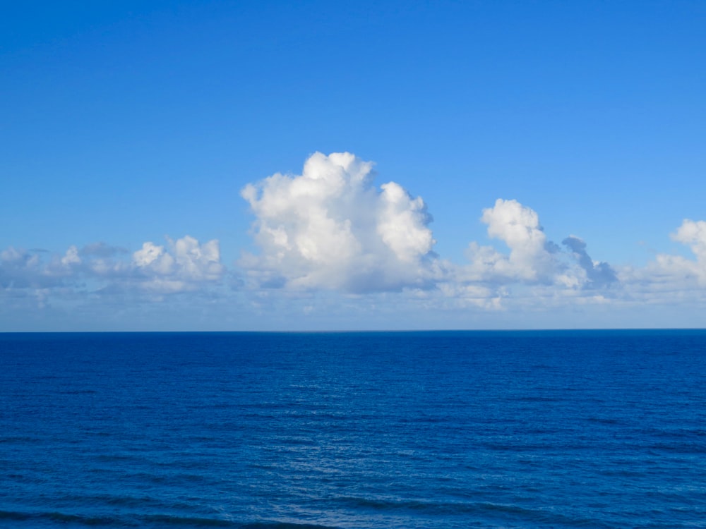 昼間の青い空と白い雲の下の青い海