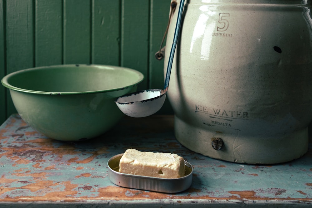 白い陶器のボウルの横のステンレス製の調理鍋