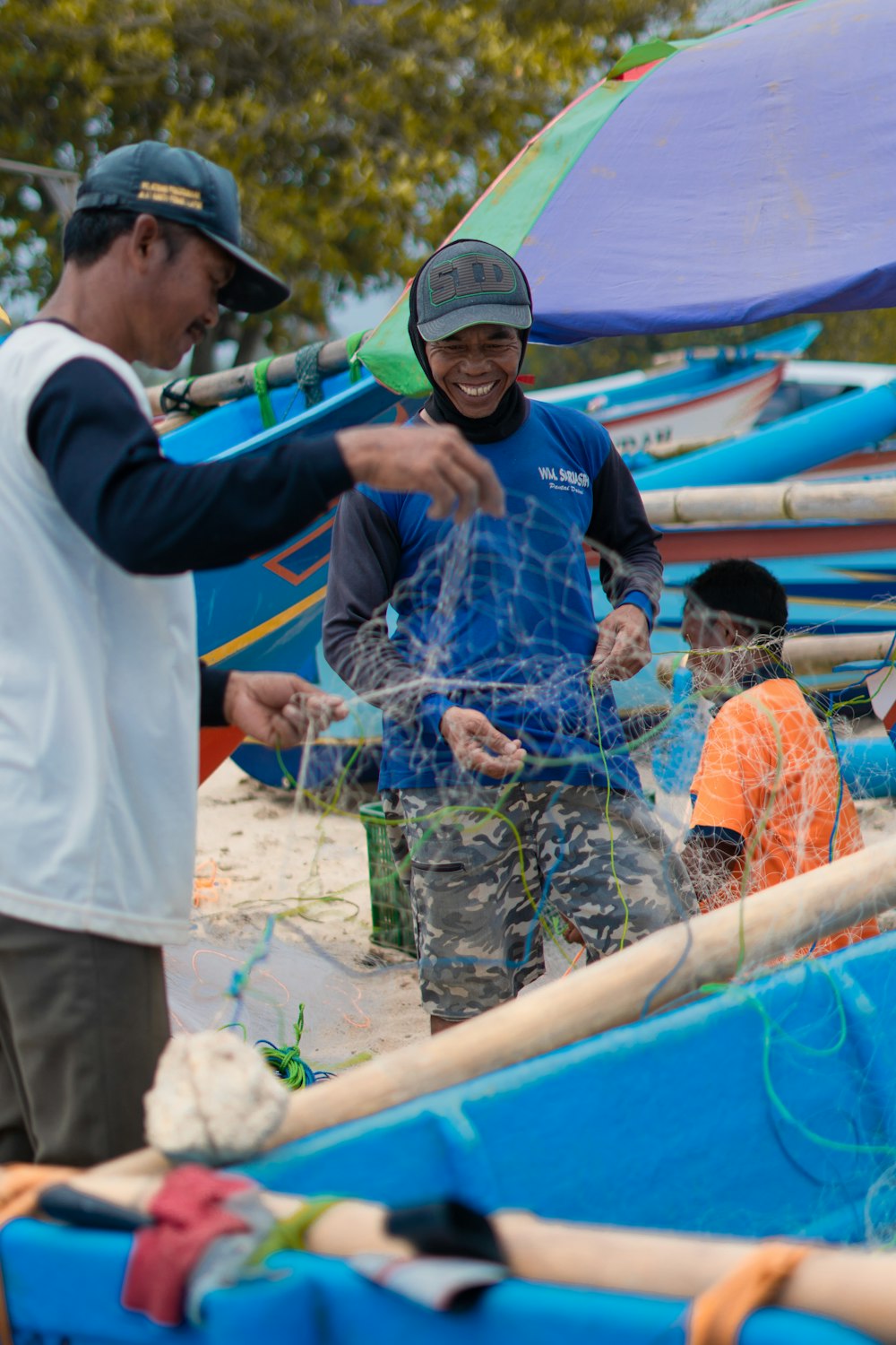 man in blue and white long sleeve shirt holding blue plastic bucket