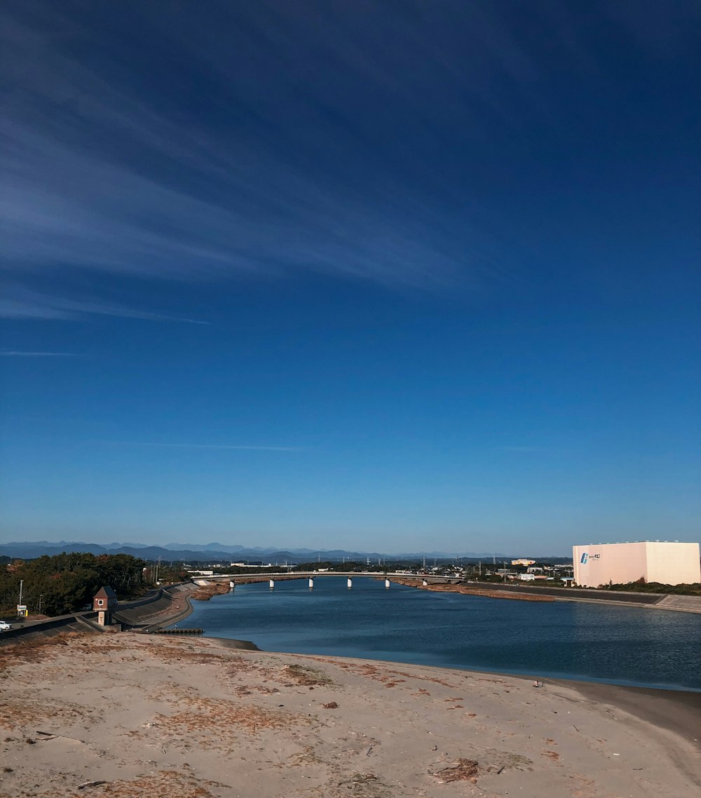 white and brown concrete building near body of water under blue sky during daytime