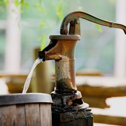 water pouring from brown wooden bucket