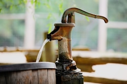 water pouring from brown wooden bucket