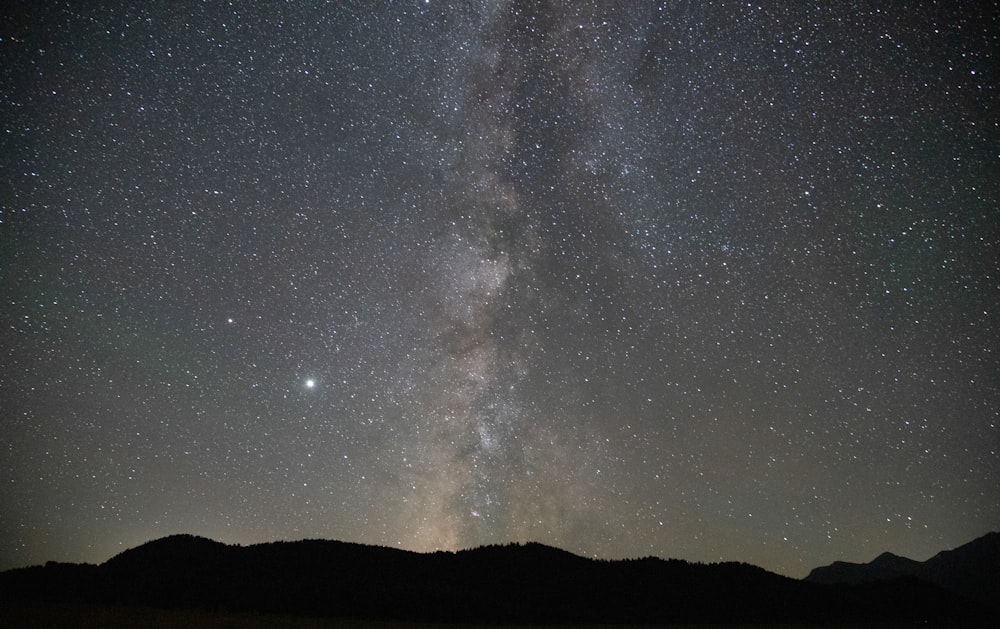 silhouette of mountain under starry night