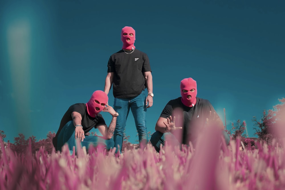 man in black crew neck t-shirt and blue denim jeans sitting on pink flower field