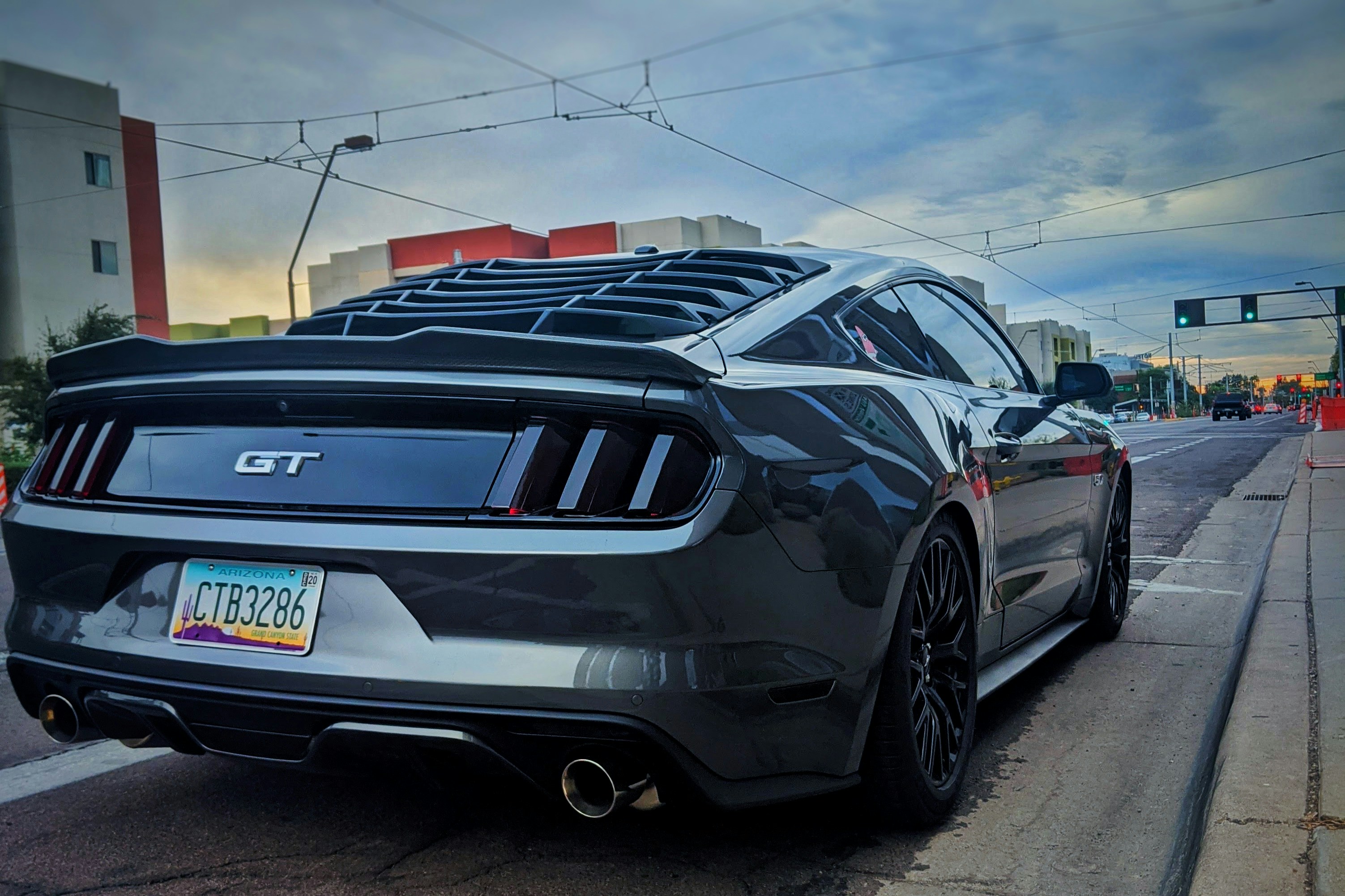 White Ford Mustang EcoBoost parked on a city street in afternoon light