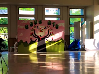 Kristi painting a colorful mural on a cozy living room wall, sunlight streaming through the windows.