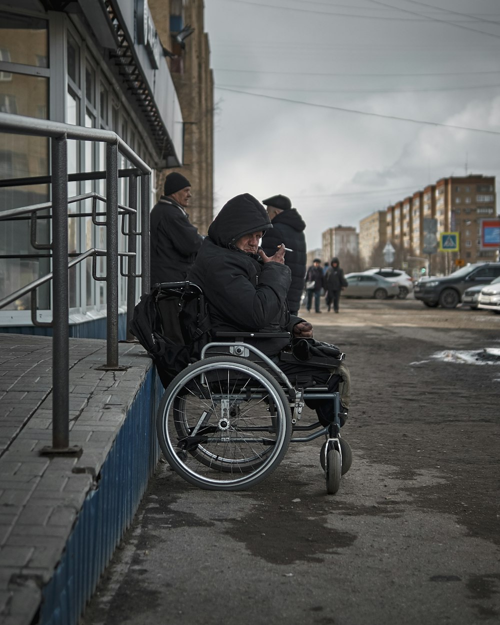 man in black jacket sitting on black wheelchair