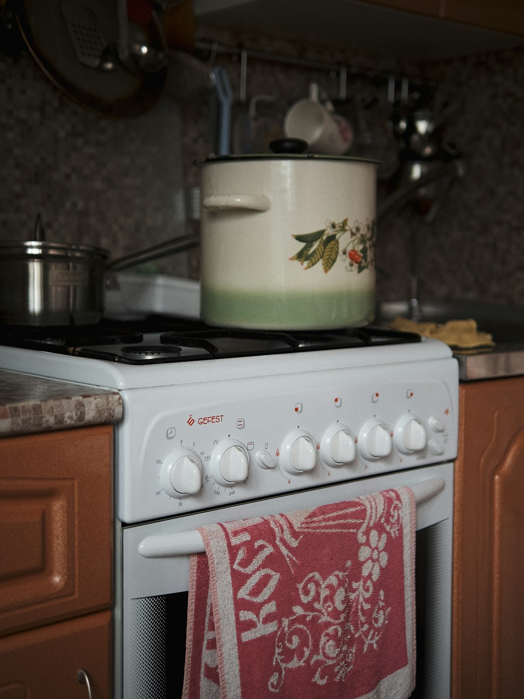 white and red cooking pot on white gas range