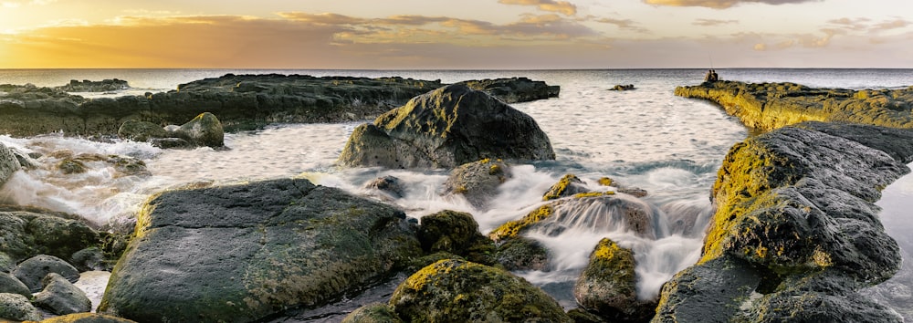 brown rock formation on body of water during daytime