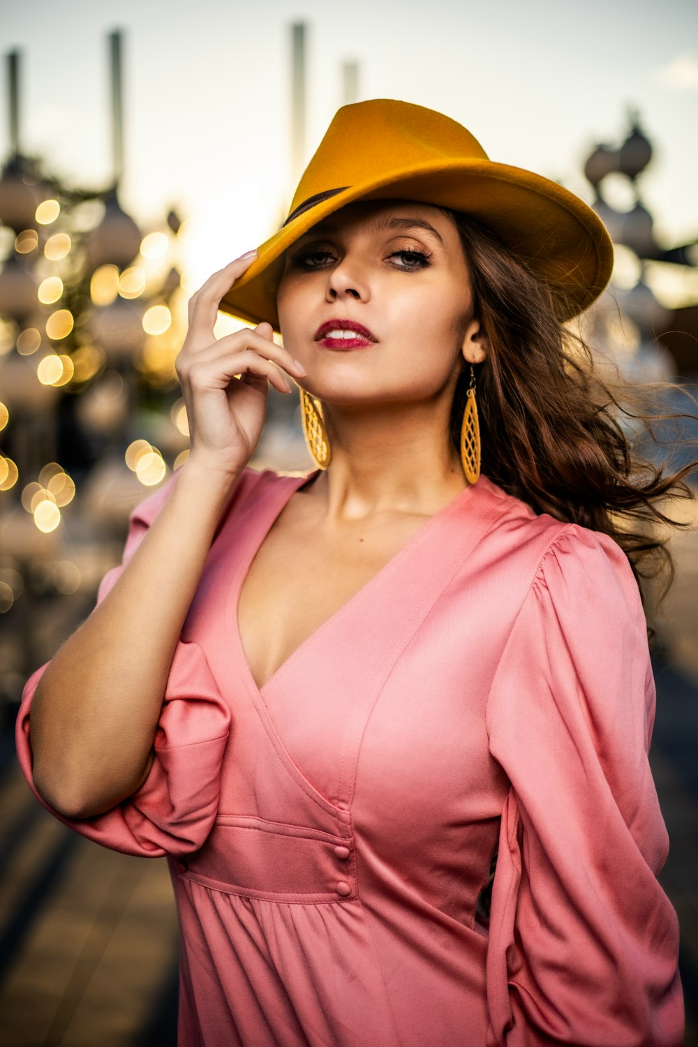 femme en chemise à col en v rose portant un chapeau marron
