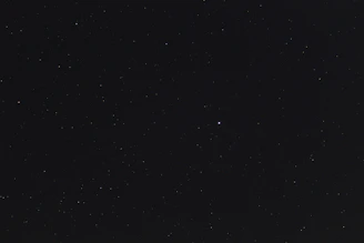 A young girl reaching out to a shining star amid a backdrop of twinkling constellations.
