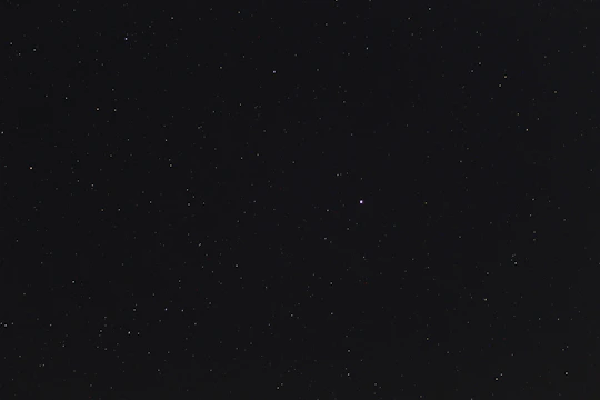 A young girl reaching out to a shining star amid a backdrop of twinkling constellations.