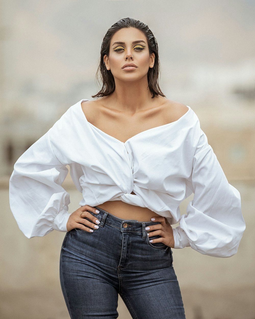 mulher na camisa branca de manga comprida e jeans jeans azuis