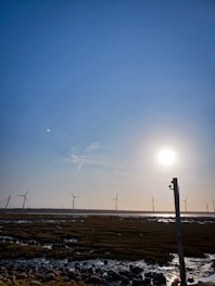 Modern wind turbines spinning on a breezy day across open fields.