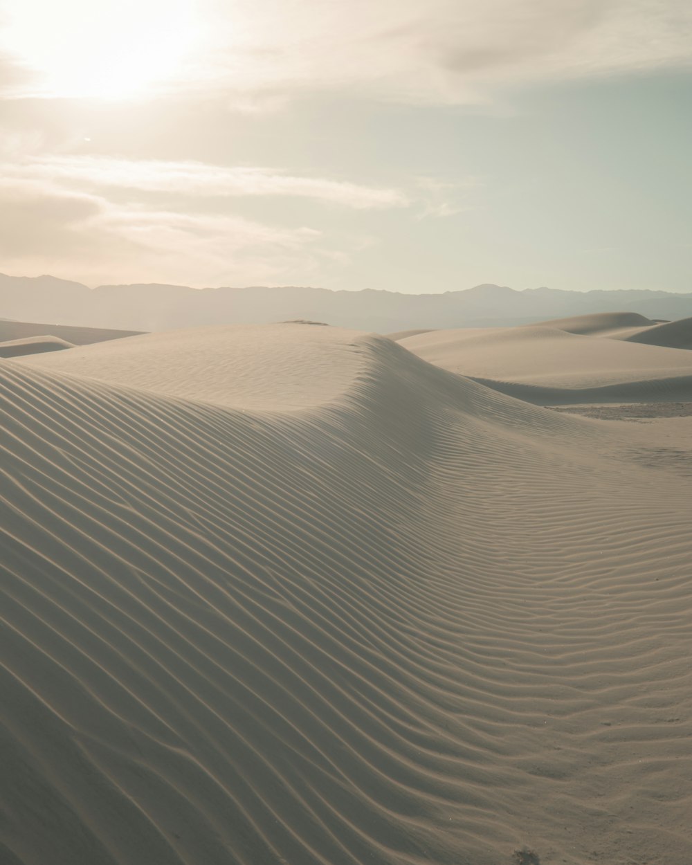 brown sand under white clouds during daytime