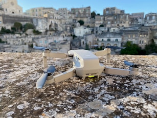 white and gray drone on rocky ground