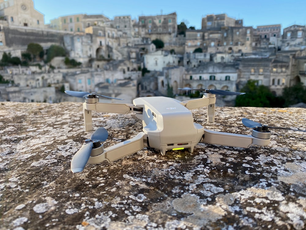 white and gray drone on rocky ground