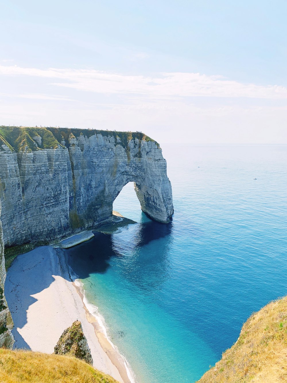 gray and green rock formation on sea during daytime