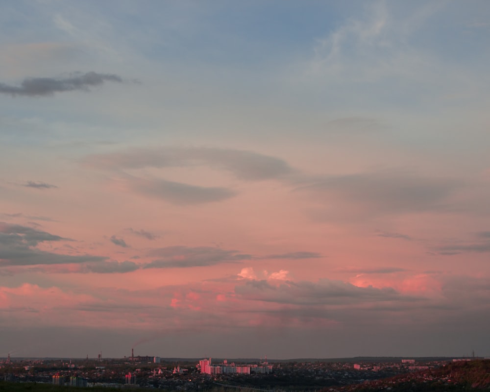 city skyline under cloudy sky during sunset