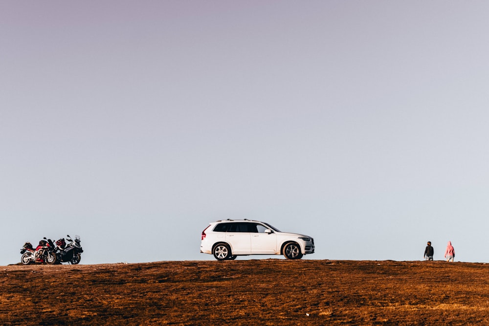 white coupe on brown field