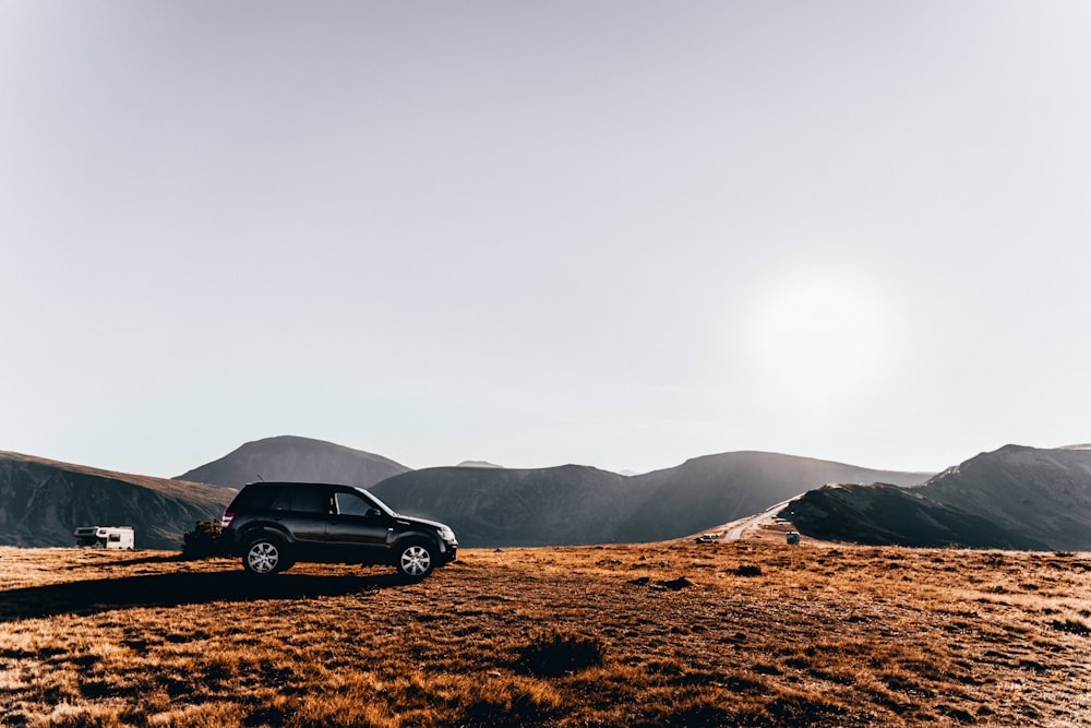 black coupe on brown field during daytime