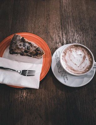 A slice of panettone on a plate with a cup of coffee, ready to enjoy.