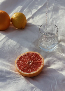 orange fruit beside clear drinking glass