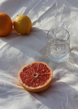 orange fruit beside clear drinking glass